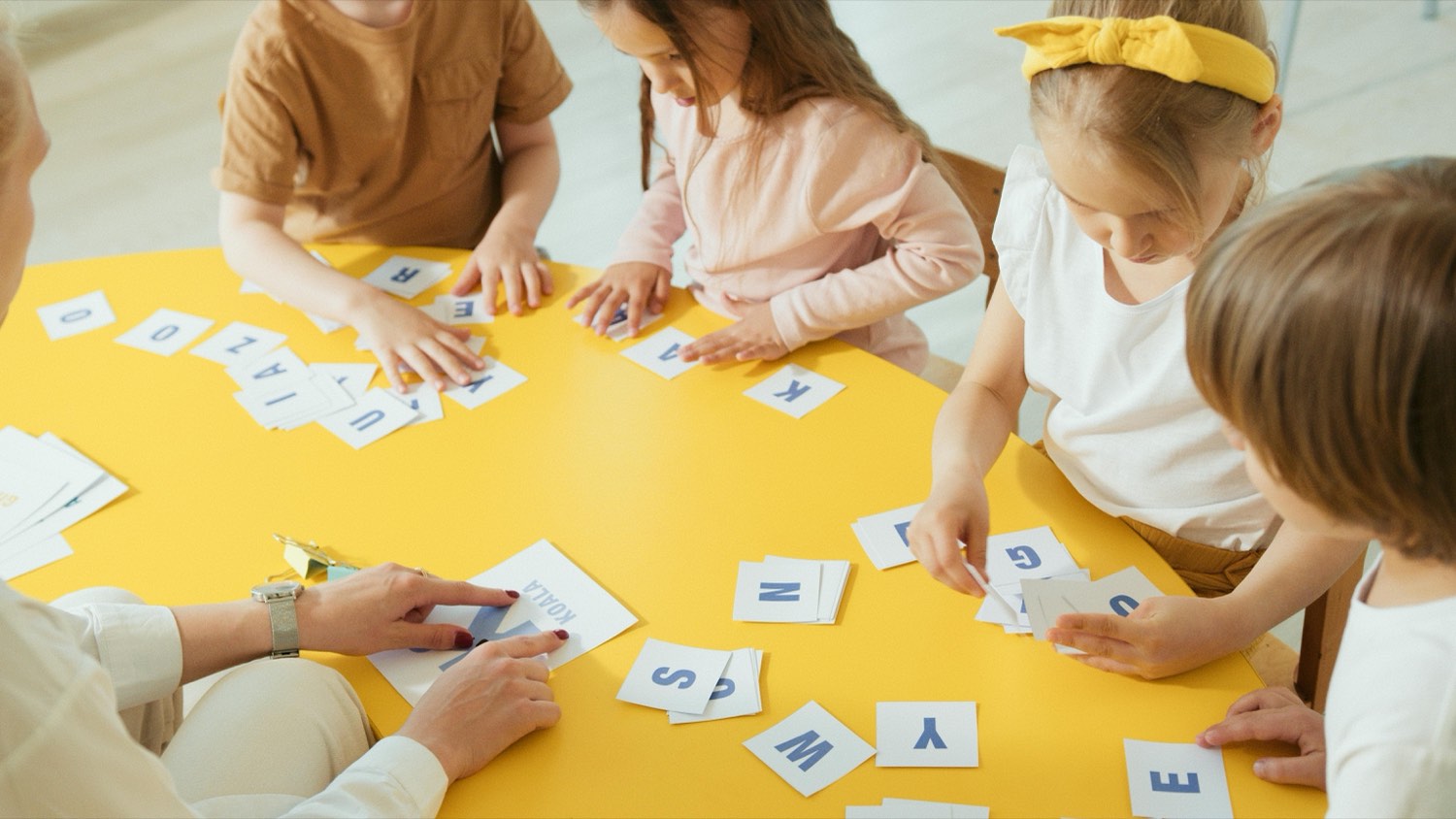 Children working together with letter cards during a Hello Learners literacy session