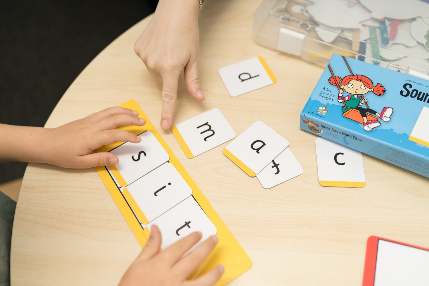 A child building words with letter tiles during a phonics activity