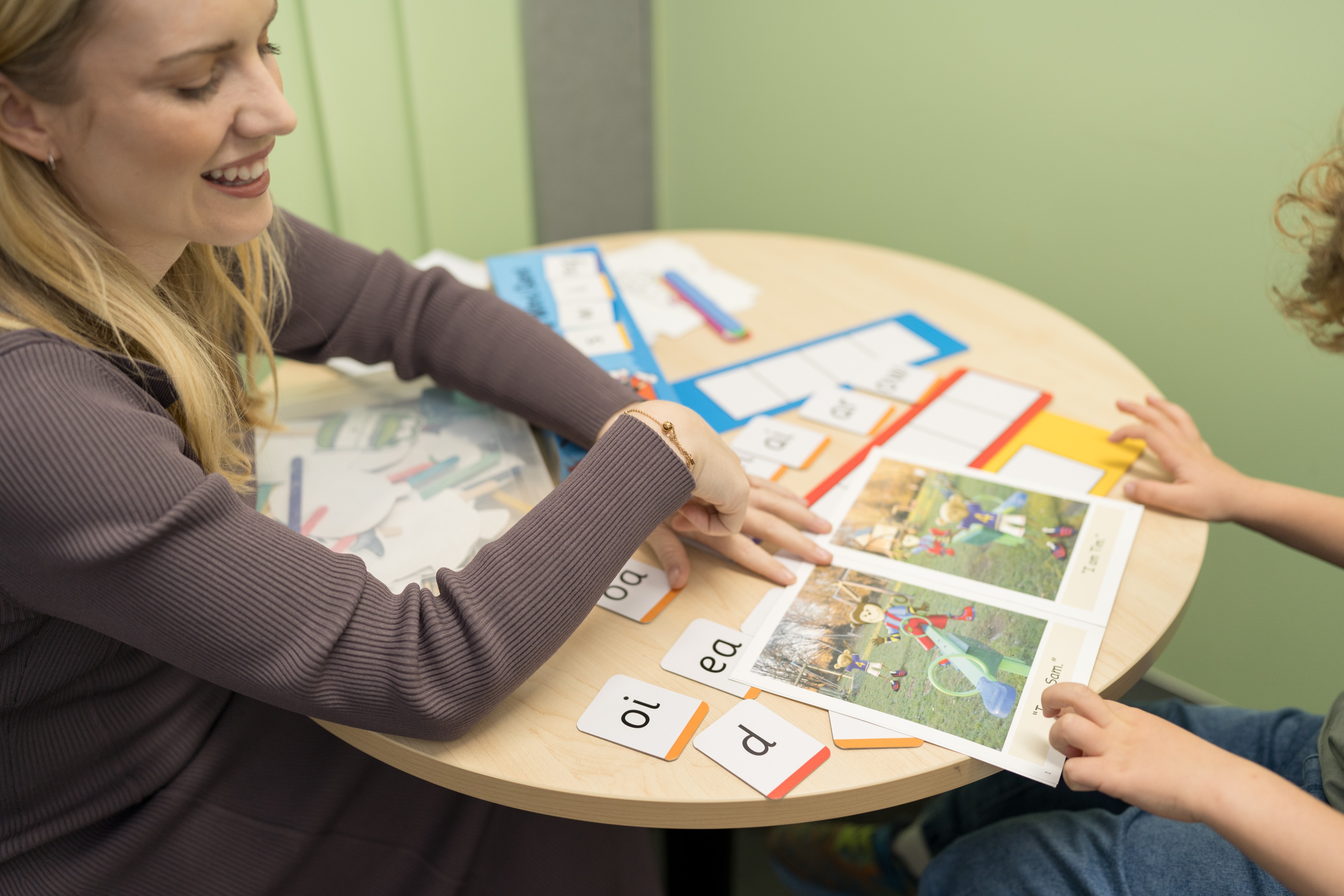 Speech pathologist working one-on-one with a child using phonics cards