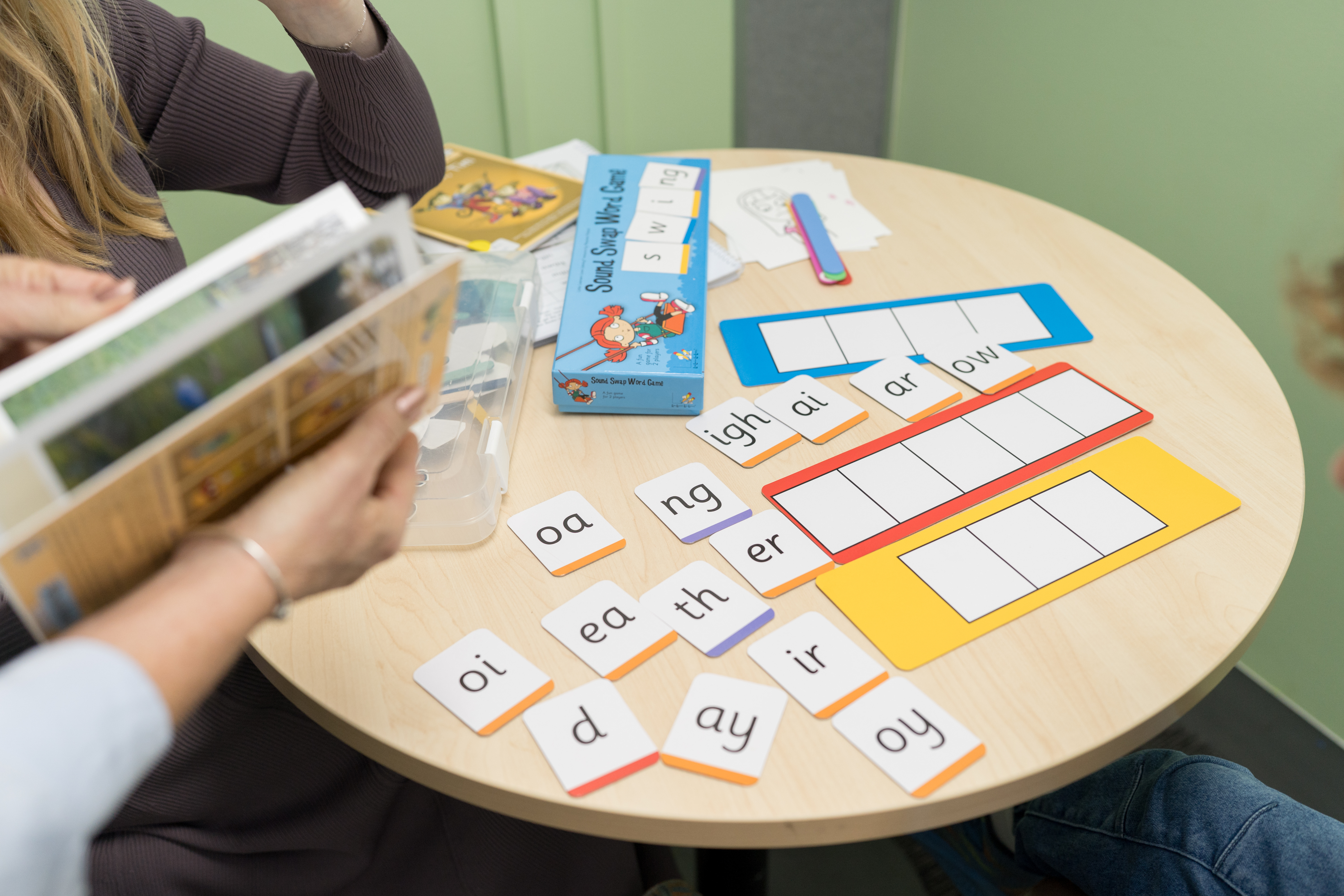 Phonics cards and word-building materials laid out on a therapy table